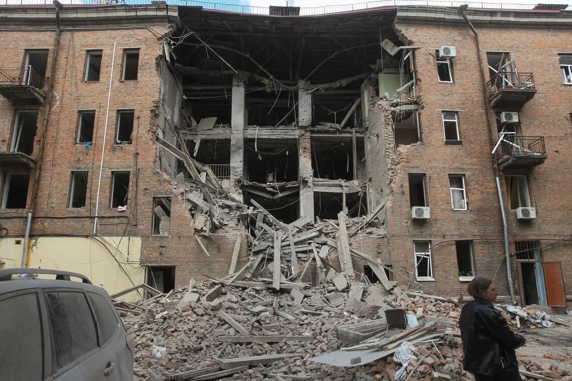 A resident stands in front of a residential building hit during a midday Russian drone strike, amid Russia's attack on Ukraine, in Dnipro, Ukraine, on April 25.