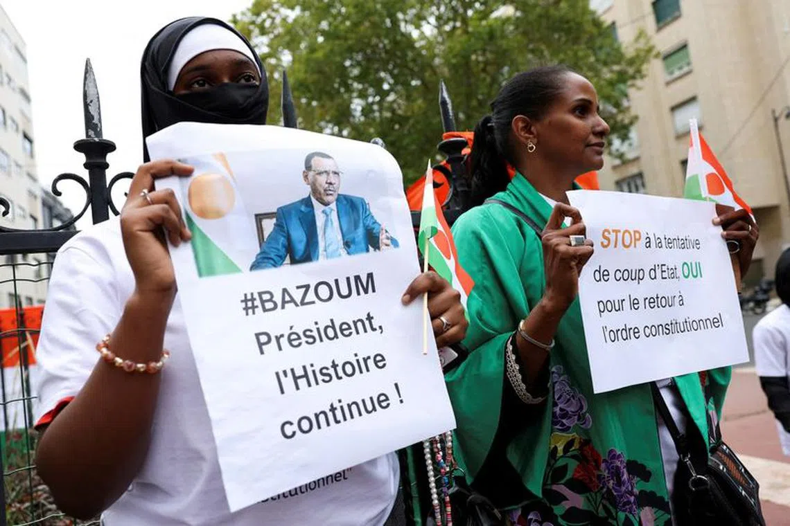 FILE PHOTO: Demonstrators hold placards and Niger's flags as they gather outside Niger's embassy in support of the President of Niger Mohamed Bazoum in Paris, France, August 5, 2023. REUTERS/Stephanie Lecocq/File Photo