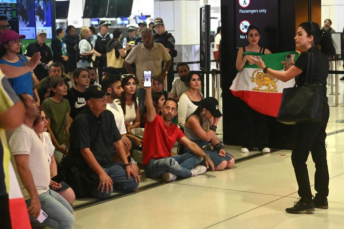 Supporters of the Iranian women's soccer team gather at Sydney Airport, after five of the players were granted asylum, in Sydney, Australia, March 10, 2026. REUTERS/Jeremy Piper