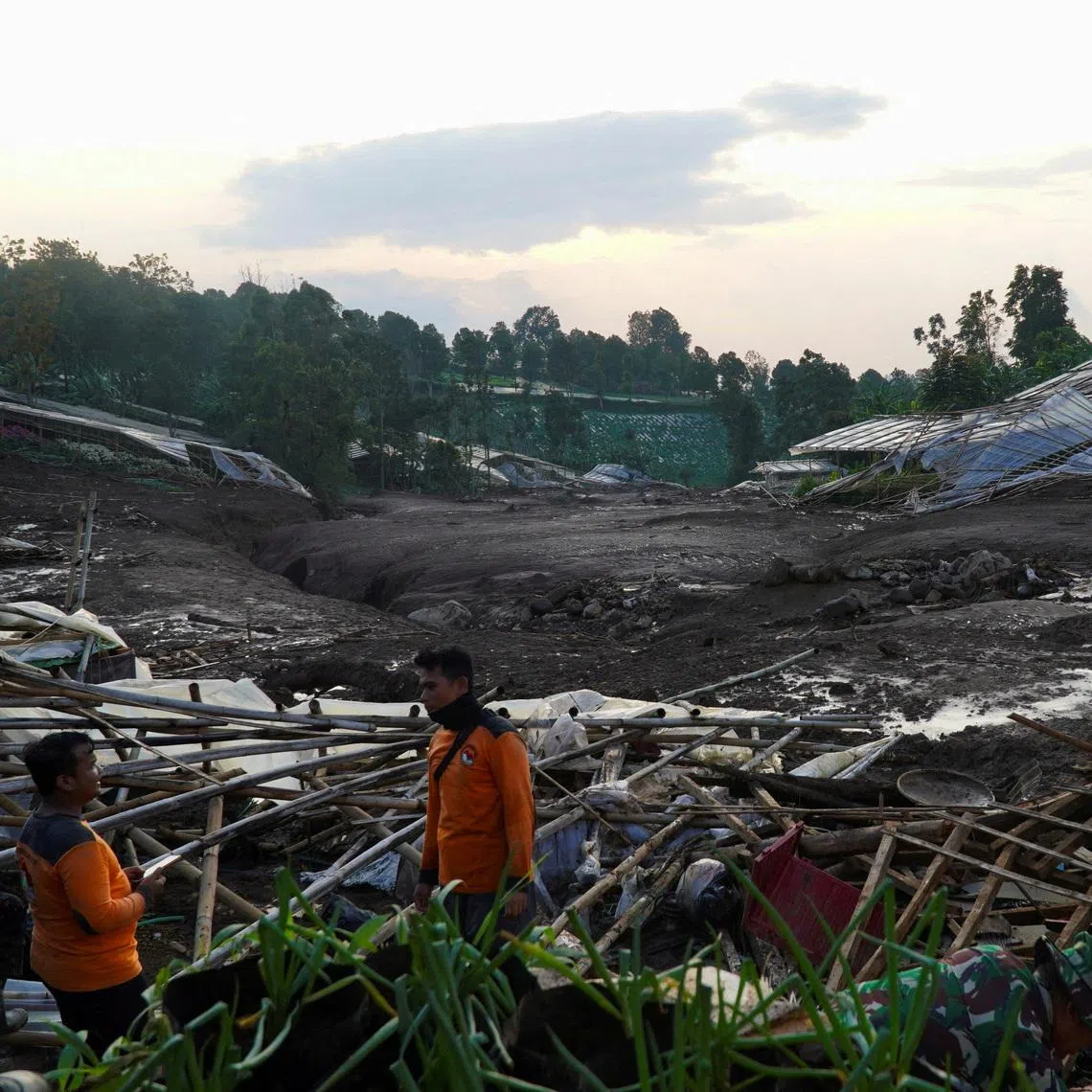 Indonesian rescue members stand near damaged houses after a landslide hit Pasirlangu village, West Bandung, West Java province, Indonesia, January 24, 2026. REUTERS/Yusep Maulana