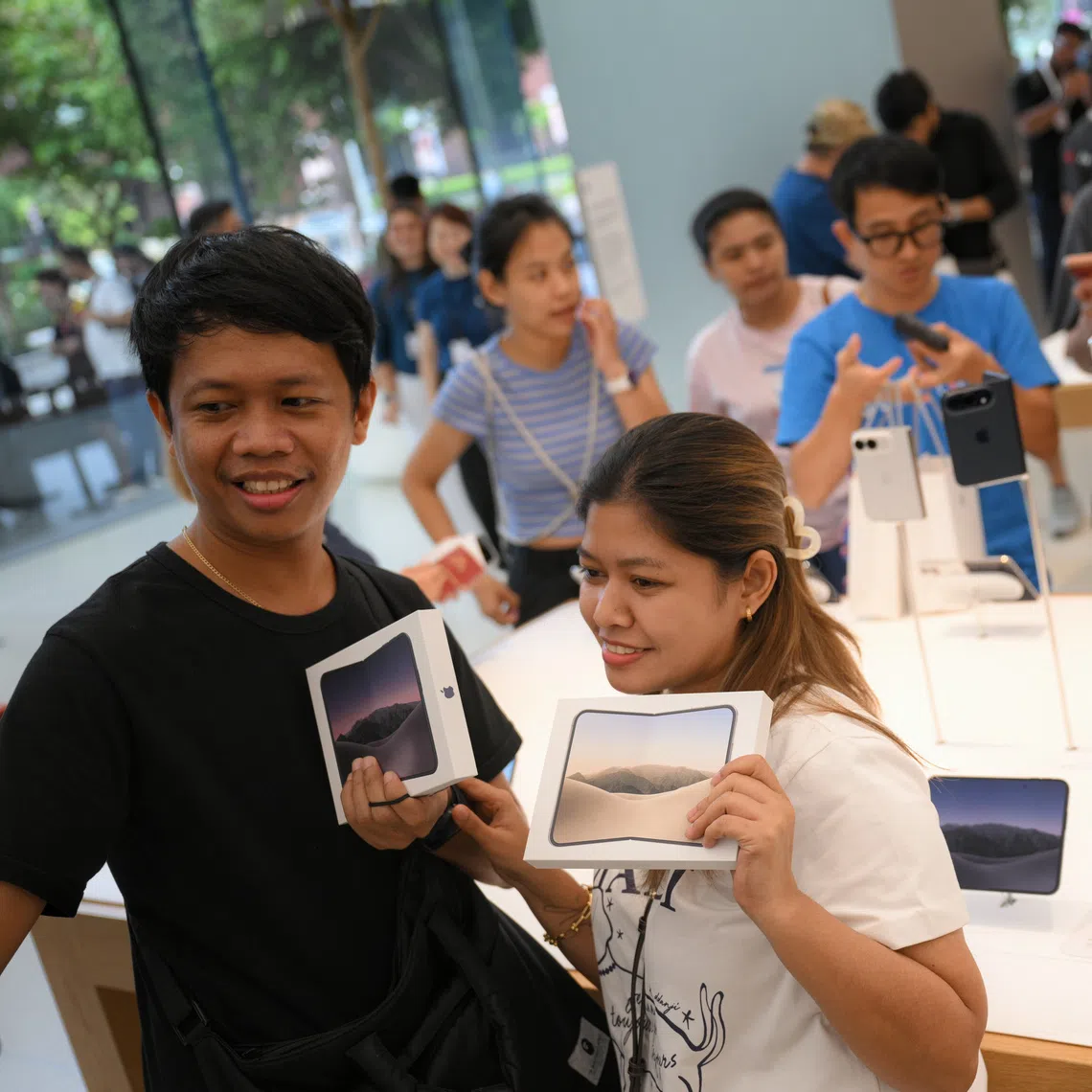 Customers with their newly purchased Apple iPhone Duo at the Apple store in Orchard Road on Oct 23.