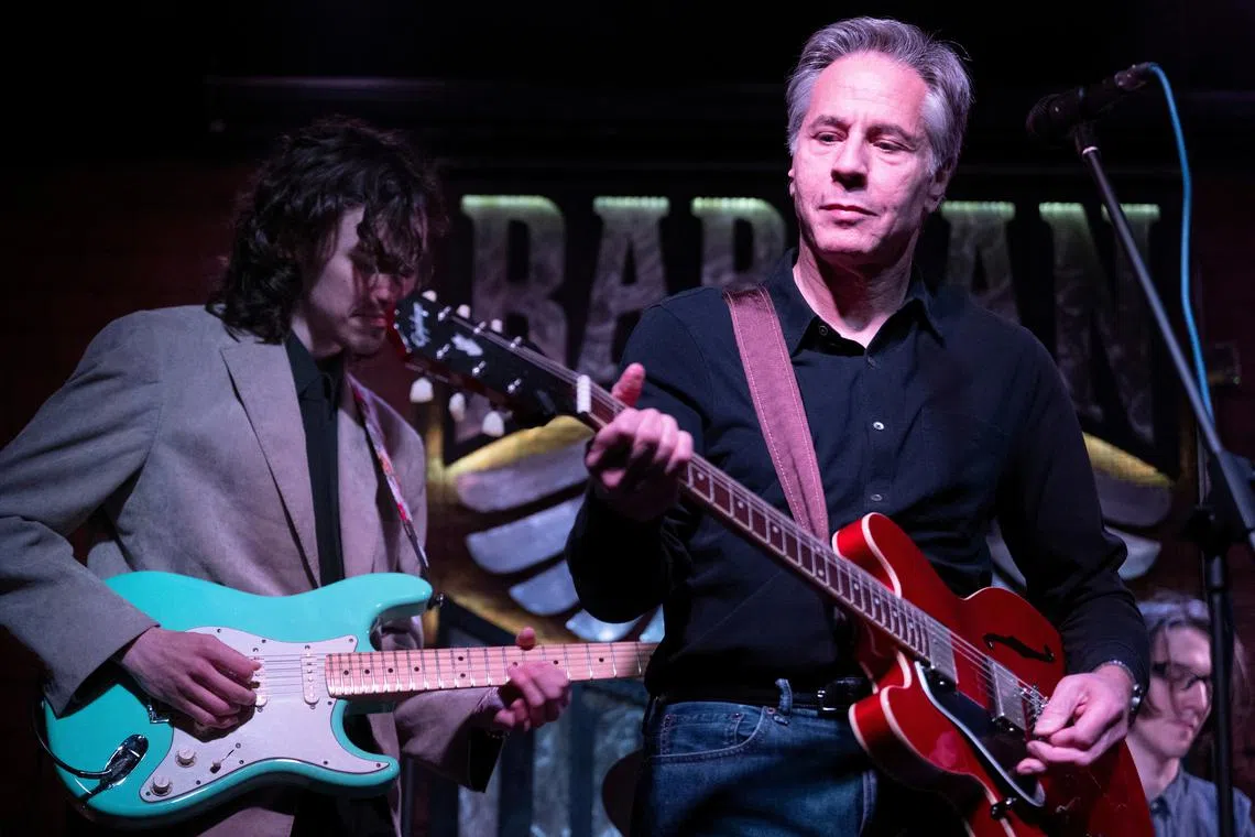 U.S. Secretary of State Antony Blinken performs \"Rockin' in the Free World\" with members of The 1999 band at the Barman Dictat bar as he visits Kyiv, Ukraine, on May 14, 2024.    BRENDAN SMIALOWSKI/Pool via REUTERS