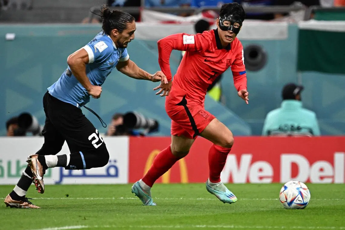 South Korea's midfielder #07 Son Heung-min runs with the ball past Uruguay's defender #22 Martin Caceres during the Qatar 2022 World Cup Group H football match between Uruguay and South Korea at the Education City Stadium in Al-Rayyan, west of Doha on November 24, 2022. (Photo by Anne-Christine POUJOULAT / AFP)
