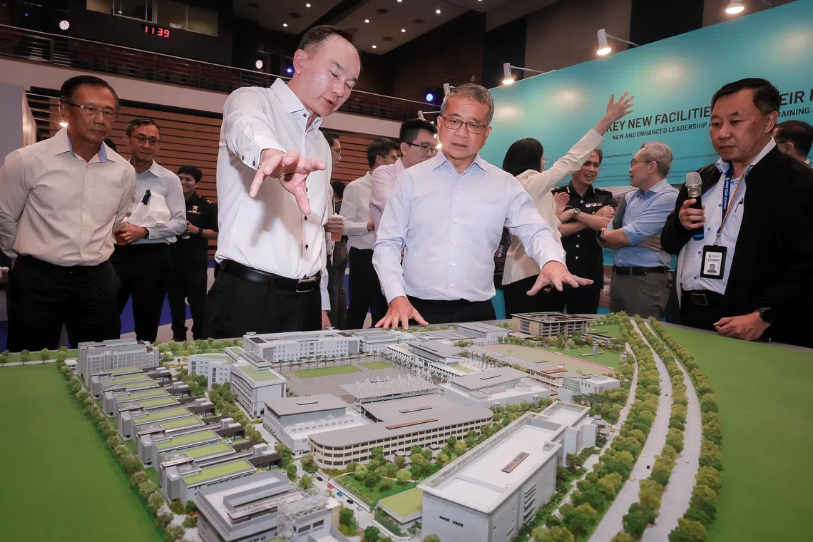 Minister for Law Edwin Tong views a model of the Home Team Academy on Sept 8. With him is Home Team Academy chief executive Wilson Lim (white top).