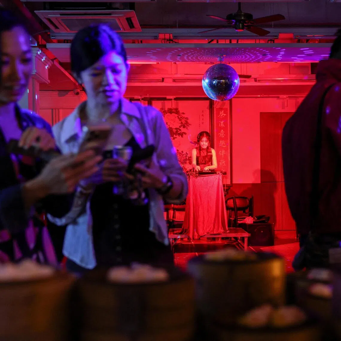 A DJ plays music as customers take photos of dim sums placed on traditional steamers at Lin Heung Lau teahouse in Hong Kong, China, on May 9. 