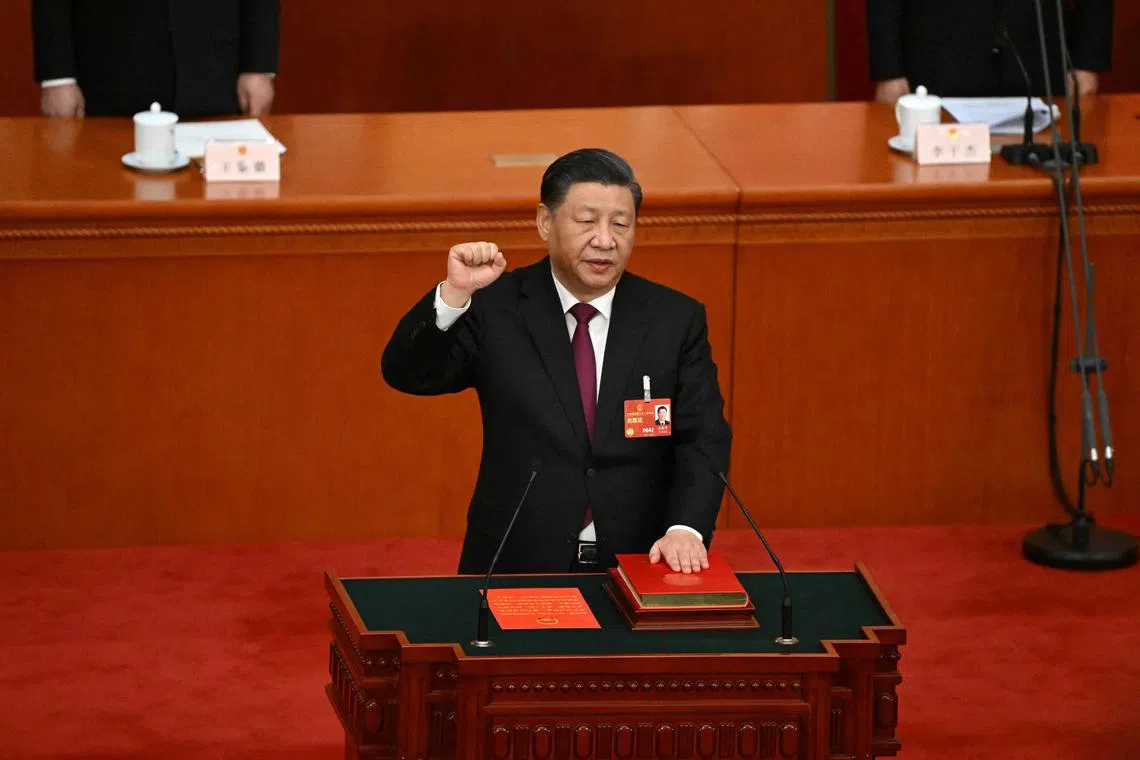 China's President Xi Jinping swearing under oath after being re-elected as president for a third term on March 10, 2023.