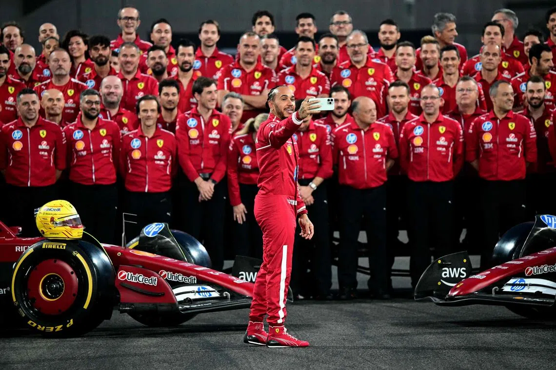 Ferrari's Lewis Hamilton takes a photo of the team after a group photo session ahead of the Abu Dhabi Grand Prix.