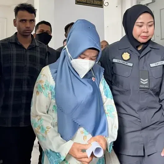Bangladeshi Sultan Md (left) and Indonesian Anita Lukman (centre) are seen at the Sessions Court in Johor Bahru, where they were charged with littering in public.
