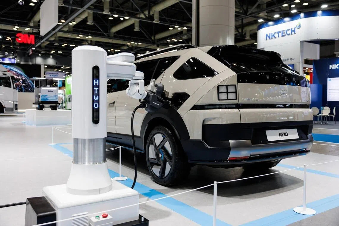A hydrogen charging robot charging an electric vehicle at the World Hydrogen Expo on Dec 4, in South Korea.