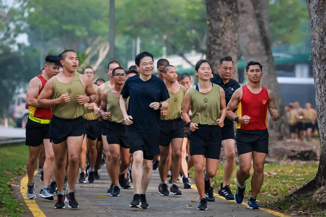 Prime Minister Lawrence Wong running with SAF recruits at the Basic Military Training Centre at Pulau Tekong on Aug 27, 2024.