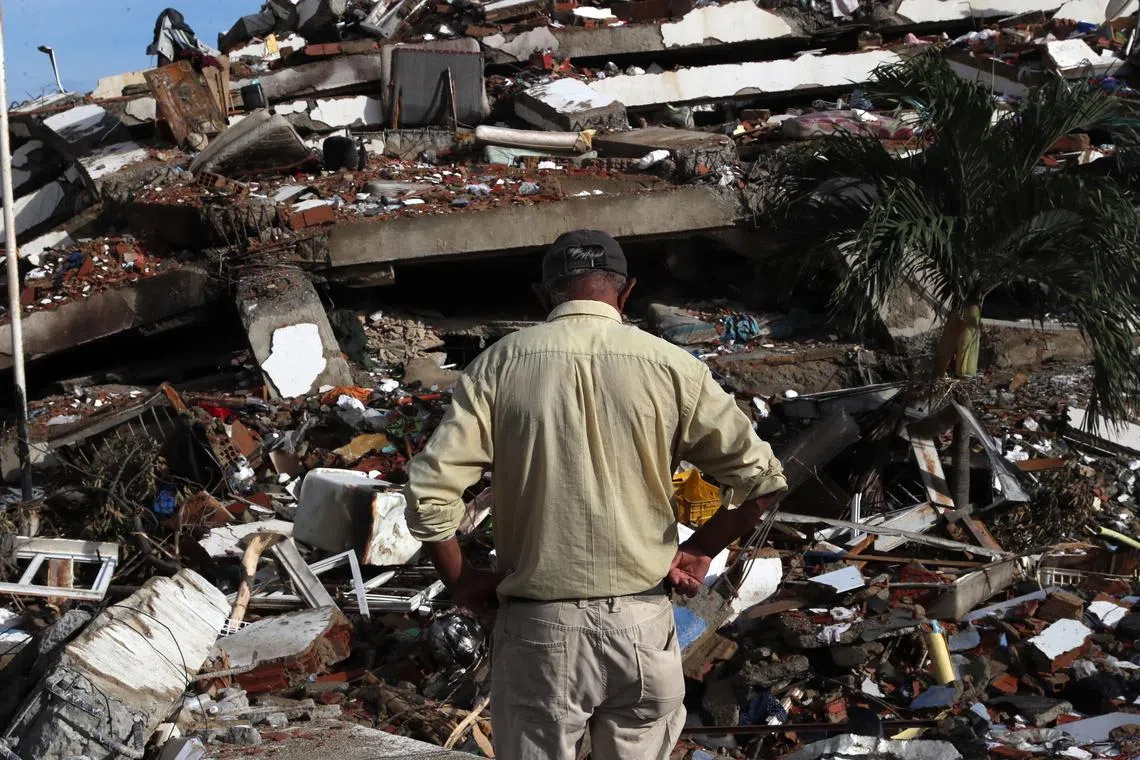 epa13076519 A person observes the rubble of destroyed buildings in La Guaira, Venezuela, 30 June 2026. The death toll from two powerful earthquakes that struck northern Venezuela on 24 June has risen to at least 1,943, with 10,571 people injured, according to National Assembly President Jorge Rodriguez. EPA/RAUL MARTINEZ