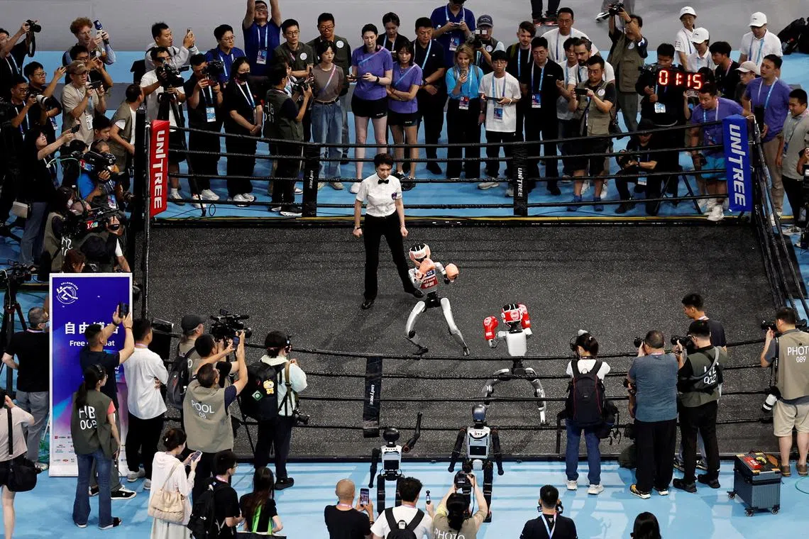 A crowd watching humanoid robots competing in a kickboxing match at the inaugural World Humanoid Robot Games, at the National Speed Skating Oval in Beijing, China, on Aug 15, 2025. 