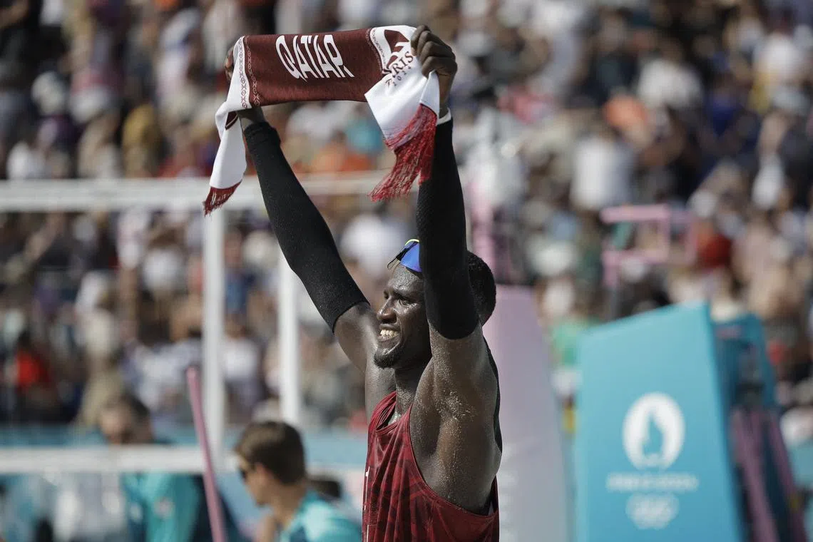 FILE PHOTO: Paris 2024 Olympics - Beach Volleyball - Men's Preliminary Phase - Pool A - Qatar vs Australia (Cherif/Ahmed vs Nicolaidis/Carracher) - Eiffel Tower Stadium, Paris, France - August 01, 2024. Cherif Younousse of Qatar celebrates with a Qatar branded scarf. REUTERS/Louisa Gouliamaki/File Photo
