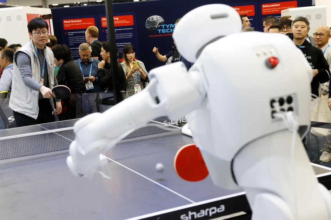 Um participante joga tênis de mesa com um robô Sharpa durante o Consumer Electronics Show (CES) anual em 7 de janeiro de 2026 em Las Vegas, Nevada. 