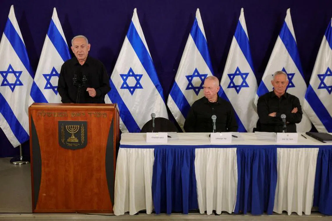 Israeli Prime Minister Benjamin Netanyahu, with Defense Minister Yoav Gallant and Cabinet minister Benny Gantz, speaks during a press conference in the Kirya military base in Tel Aviv, Israel, 28 October  2023.    ABIR SULTAN POOL/Pool via REUTERS