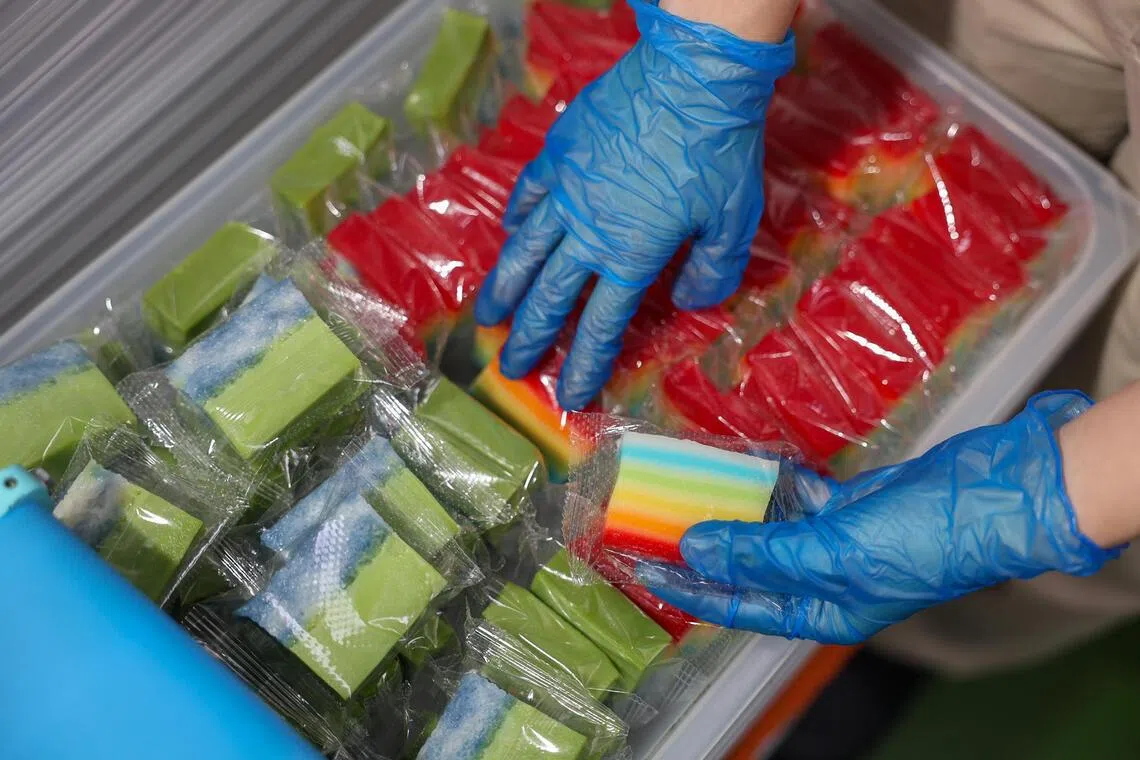 HarriAnns Nonya Table’s Kueh Salat and Rainbow Kueh being wrapped in individual packaging in JTC Bedok Food City.