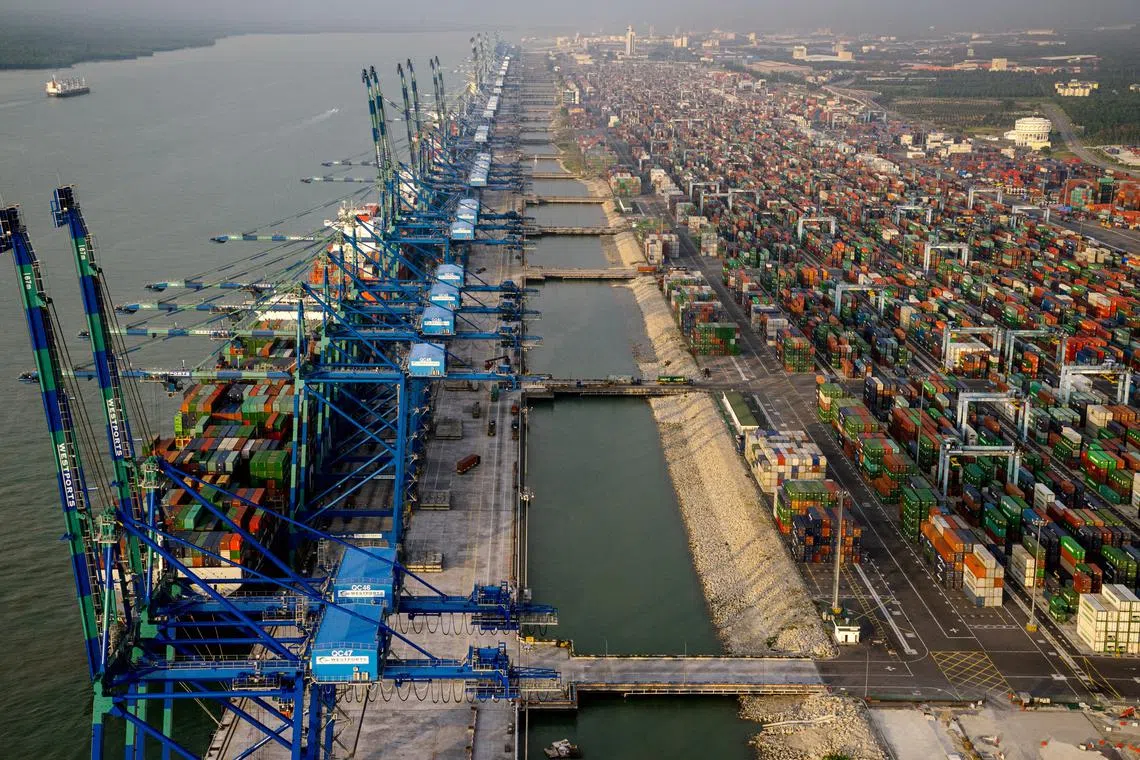 Container ships sit docked next to gantry cranes at Port Klang in this aerial photograph taken over Klang district, Selangor, Malaysia, on Saturday, Jan. 9, 2016. Malaysia's ringgit extended its worst start to a year since 2009 as a slump in Brent crude clouds the outlook for Asia's only major net oil exporter. Photographer: Sanjit Das/Bloomberg