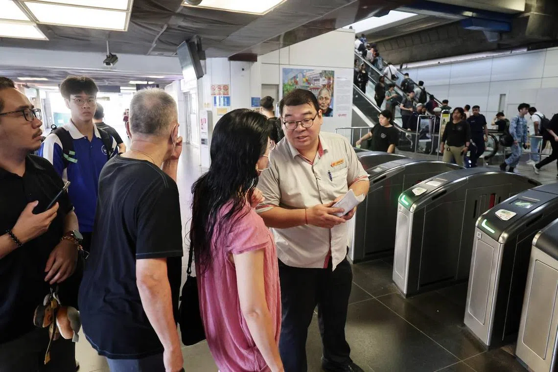 Staff explaining track fault situation and offering passengers alternatives, at Boon Lay station.