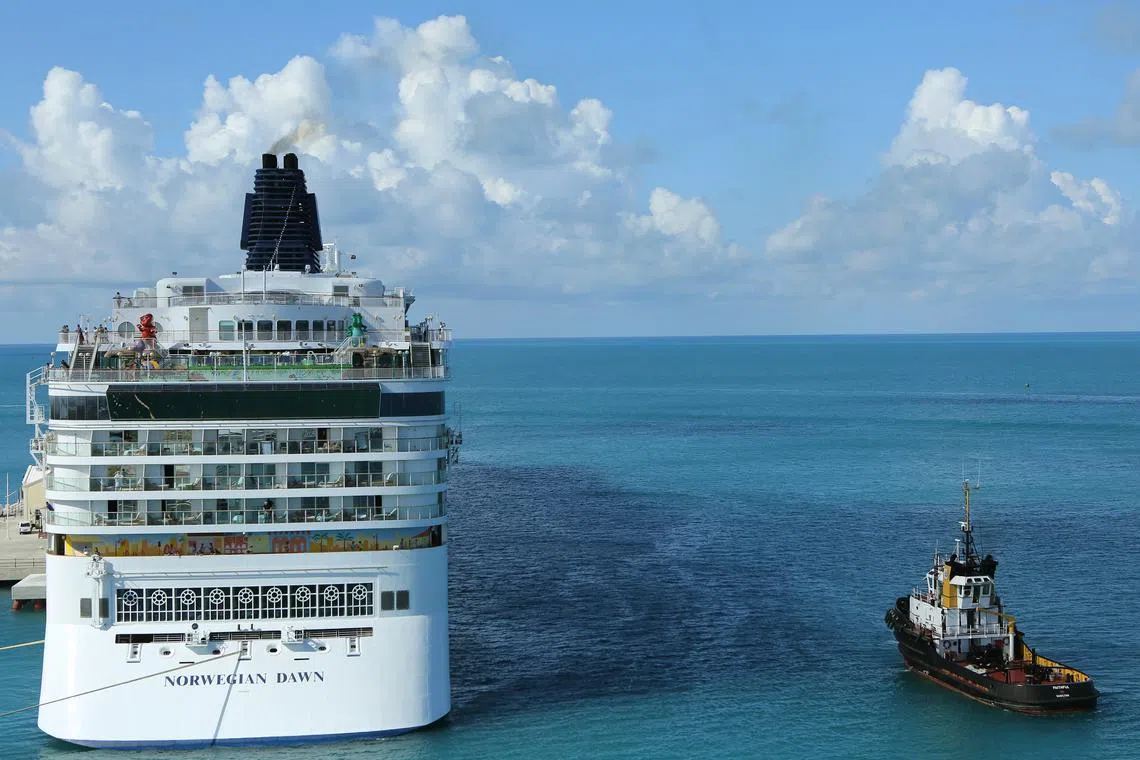 FILE PHOTO: The cruise ship of the Norwegian Cruise Line 'Norwegian Dawn\" (L) departs the Royal Naval Dockyard July 16, 2013 near the port of Hamilton, Bermuda.  REUTERS/Gary Cameron/File Photo