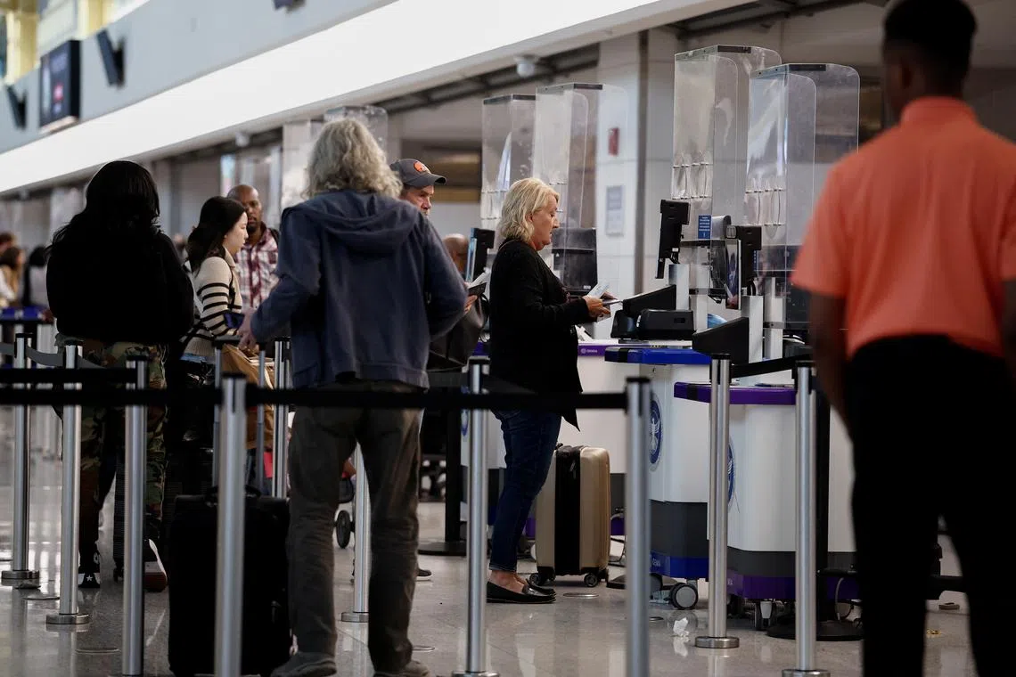 FILE PHOTO: Travelers wait in line at Ronald Reagan National Airport (DCA) ahead of the Thanksgiving holiday in Arlington, Virginia, U.S., November 27, 2024. REUTERS/Benoit Tessier/File Photo