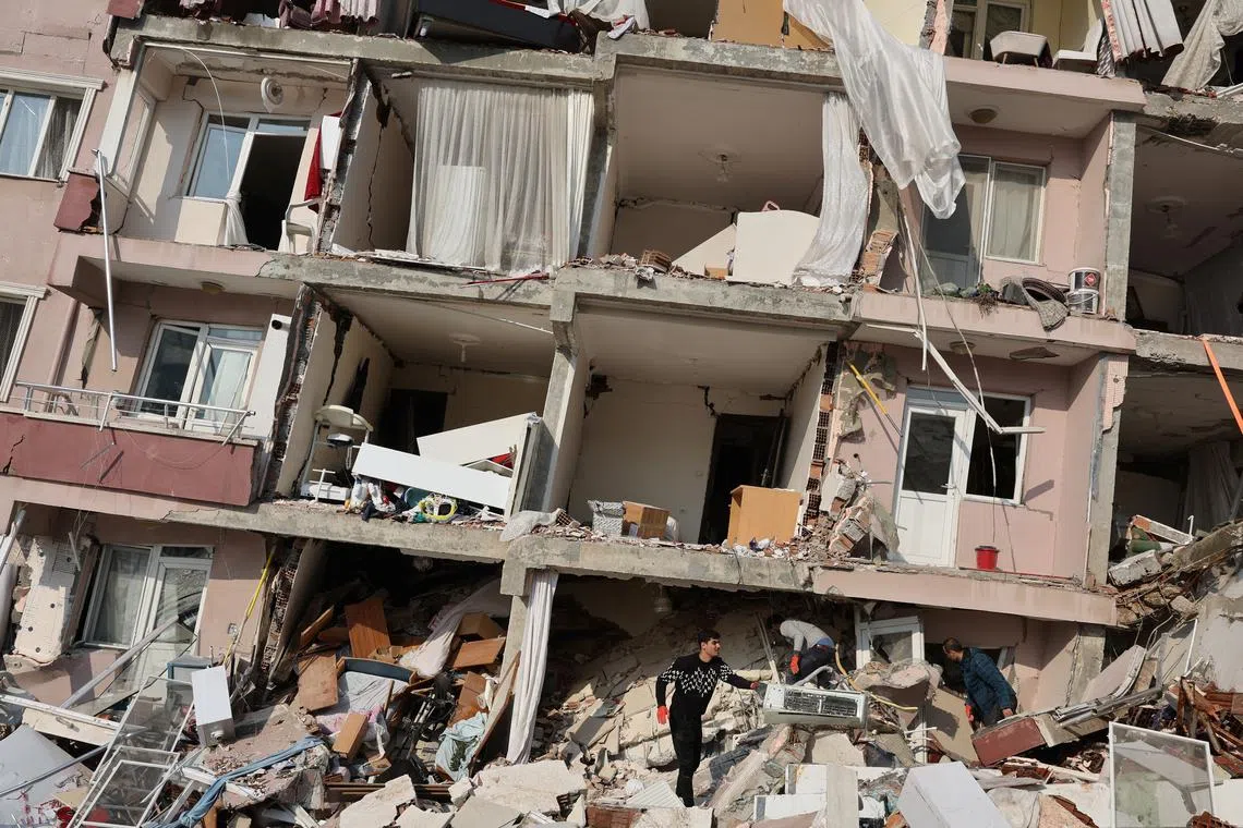 People look amid rubble as the search for survivors continues following an earthquake in Hatay, Turkey, Feb 7, 2023.