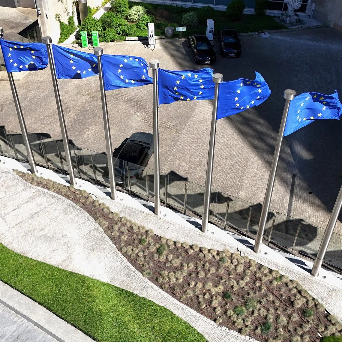 A drone view shows the European Union flags outside the European Commission headquarters, known as the Berlaymont building in Brussels, Belgium, April 29, 2026. REUTERS/Yves Herman