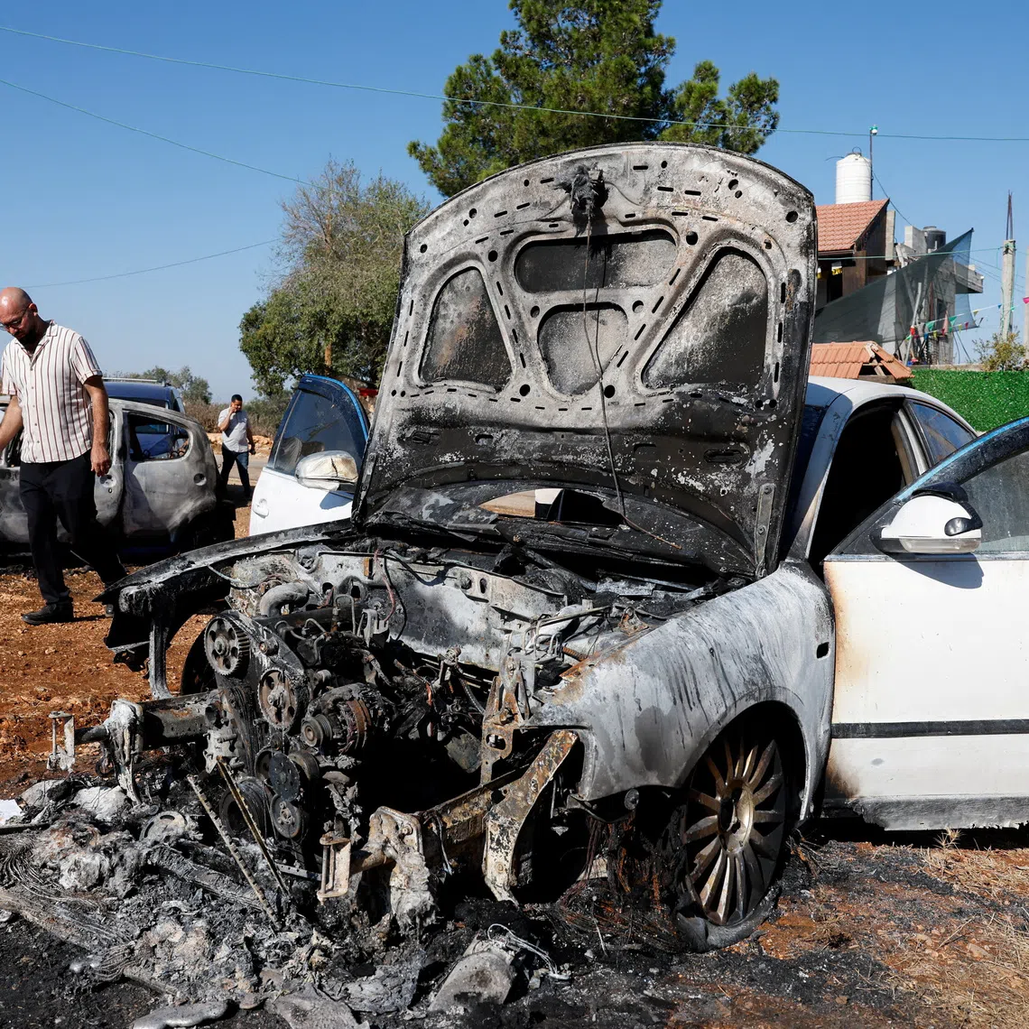 A man walks past destroyed cars, which Palestinians say were burned by Israeli settlers last night, in Beita, near Nablus, in the Israeli-occupied West Bank, September 2, 2026. REUTERS/Mohammed Torokman