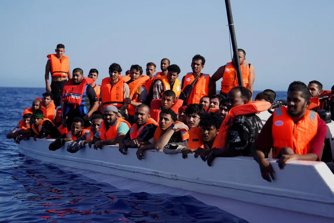 Migrants in a fiberglass boat are met by a rescue vessel on July 24, in international waters south of Lampedusa, in the Mediterranean Sea.