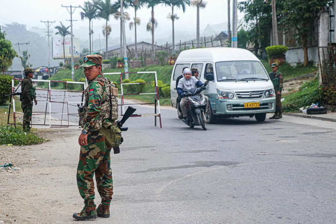 Fighters of the ethnic rebel group Ta'ang National Liberation Army (TNLA) standing guard at a check point in the town of Namhkam in northern Shan state. 