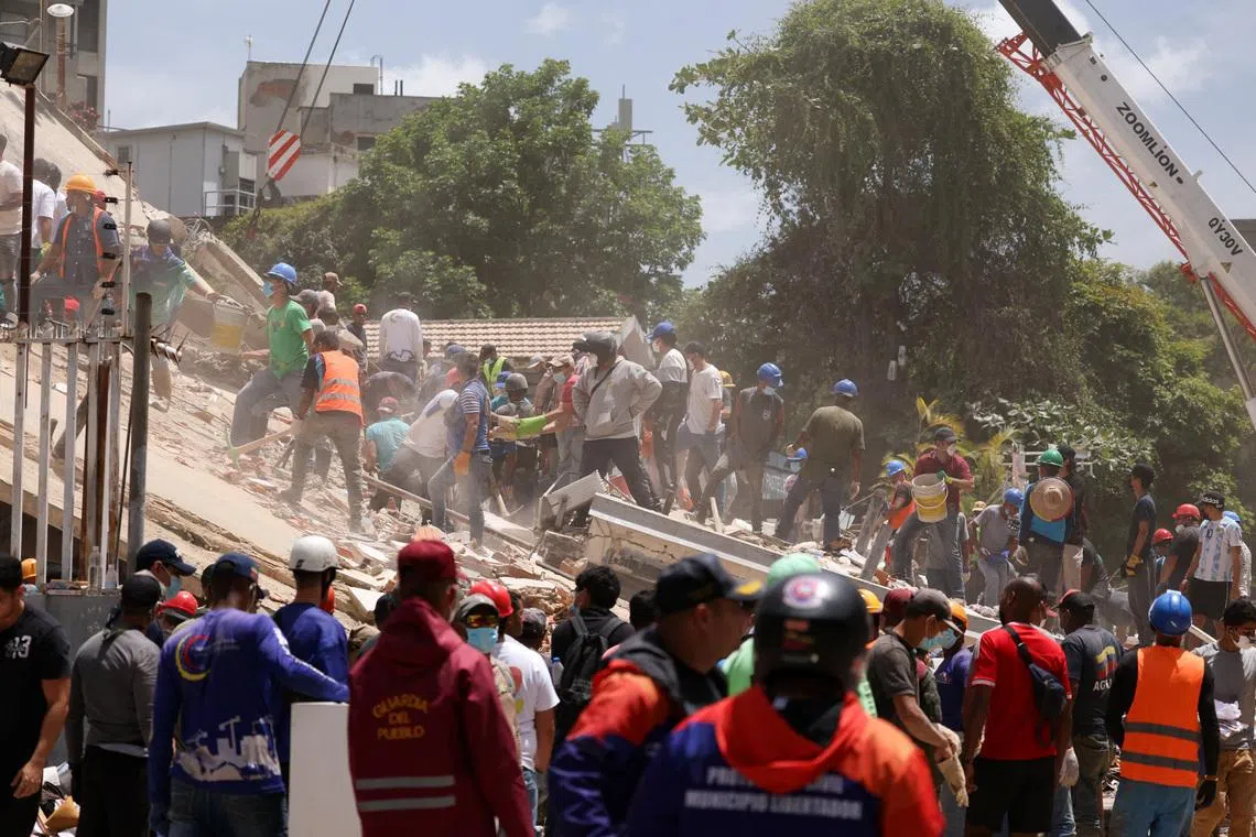People searching for casualties amid the rubble of a collapsed building, in the aftermath of earthquakes in Caracas, Venezuela, on June 25.