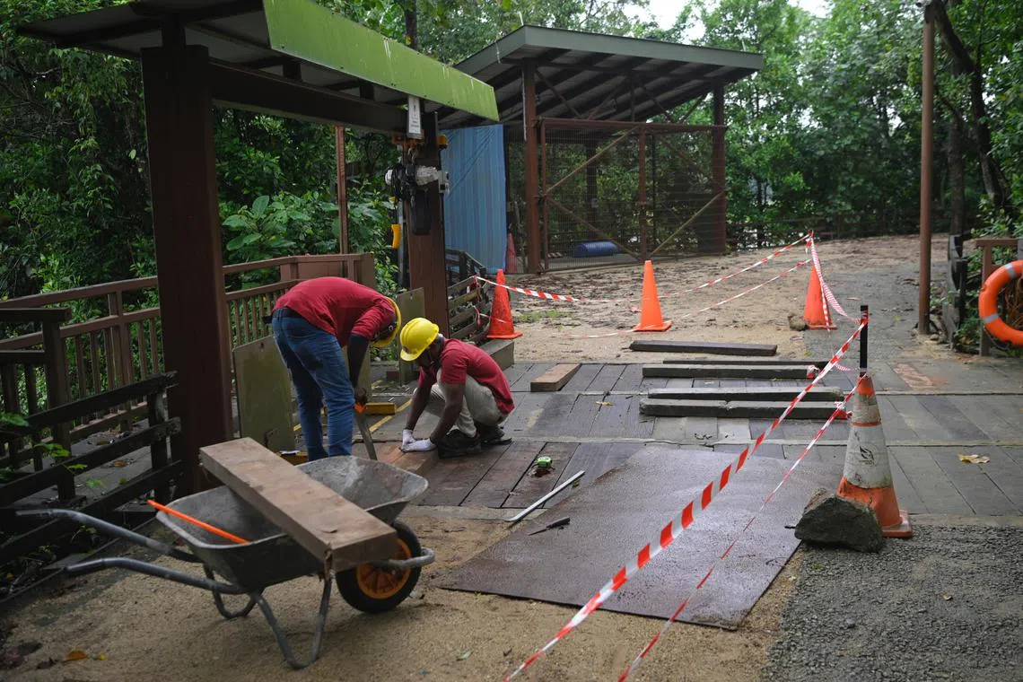 Workers patch up a hole in a crossing of a sluice gate at Sungei Buloh where a man and two-year-old daughter fell, on January 26, 2023.