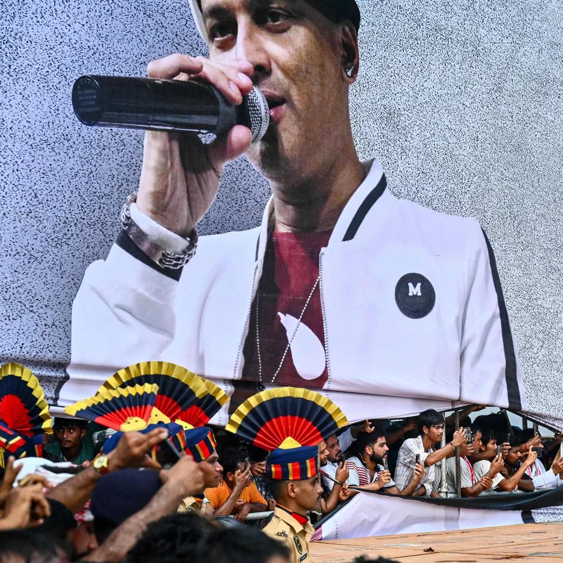 TOPSHOT - Fans throng during the cremation of Indian musician Zubeen Garg, on the outskirts of Guwahati on September 23, 2025. Zubeen Garg, 52, died by drowning in Singapore last week, triggering a massive outpouring of grief among his millions of fans in Assam, where he enjoyed a cult-like status. Tens of thousands of mourners thronged the streets of India's northeastern Assam state on September 23 to bid farewell to a flamboyant artiste, celebrated as much for his music as for his irreverent persona. (Photo by Biju BORO / AFP)