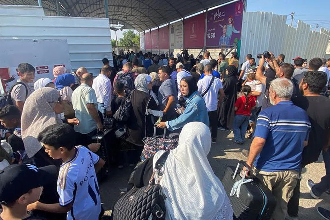 Palestinians with dual citizenship walk at the Rafah border crossing with Egypt, in the hope of getting permission to leave Gaza, amid the ongoing conflict between Israel and Palestinian Islamist group Hamas, in Rafah in the southern Gaza Strip, November 1, 2023. REUTERS/Arafat Barbakh