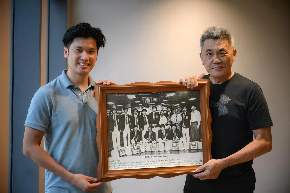 Ex-national shuttlers Derek Wong (left) and father Wong Shoon Keat, with an old team photo which the latter was featured in with the rest of the Singaporean team who went to the 1981 Thomas Cup.
