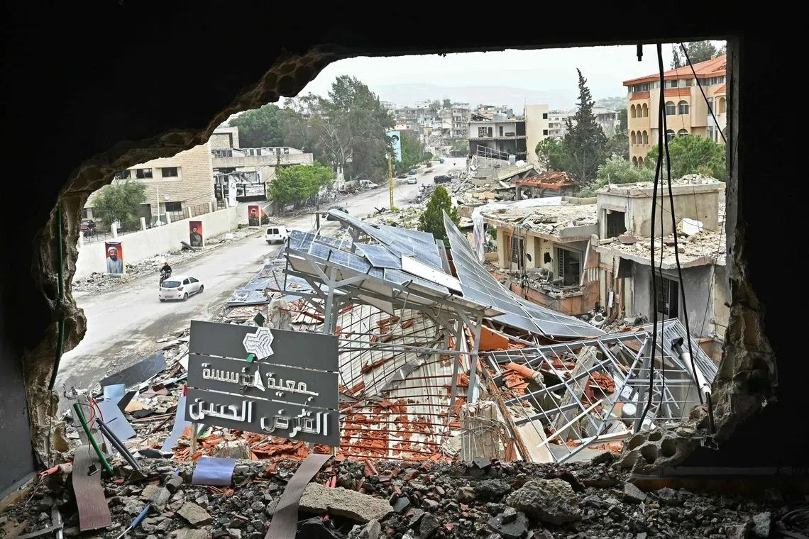 Displaced residents drive past destroyed buildings as they return to the southern Lebanese city of Nabatieh on April 18 amid the ceasefire in the Israel-Hezbollah war.