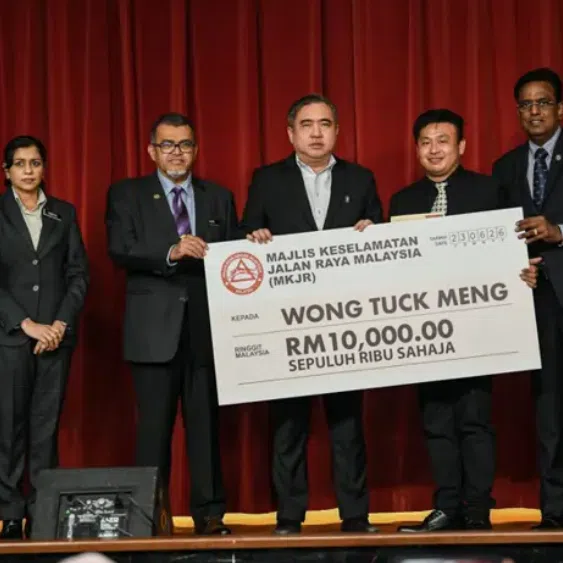 Transport minister Anthony Loke (middle) presented a mock cheque of RM10,000 (S$3,120) to lorry driver Wong Tuck Meng (second from right). 