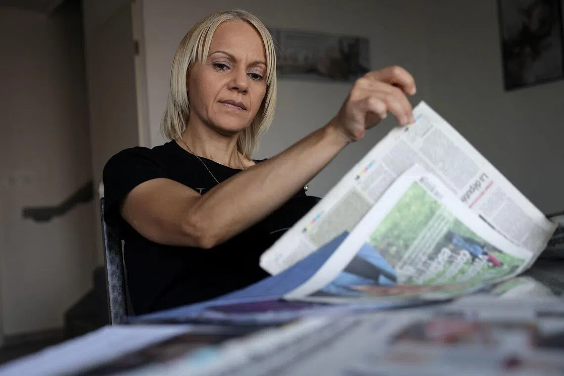 Moroccan-born Yasmina Tellal, a 42-year-old Moroccan woman, consults press clippings in southwestern France on August 15, 2025. #MeToo may have helped change the landscape for women in Hollywood and in the boardroom, but cleaners, secretaries and supermarket workers who have suffered sexual violence at work told AFP it has yet to do much for them. When women in precarious jobs speak out, these "courageous" actions receive "much less media attention" compared to those of actresses, writers, or journalists, emphasizes the European Association Against Violence Against Women at Work (AVFT). (Photo by Valentine CHAPUIS / AFP)