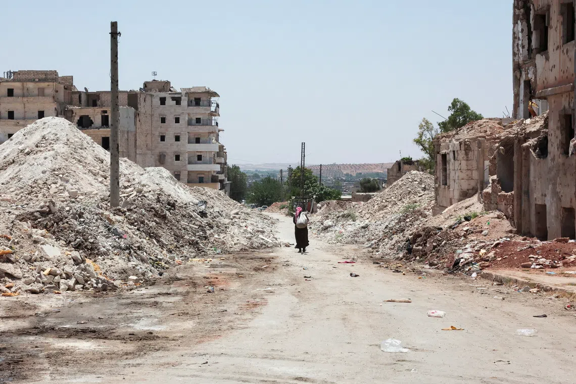 FILE PHOTO: A man walks through the destruction in the city of Aleppo, Syria, June 23, 2025. REUTERS/Mahmoud Hassano/File Photo