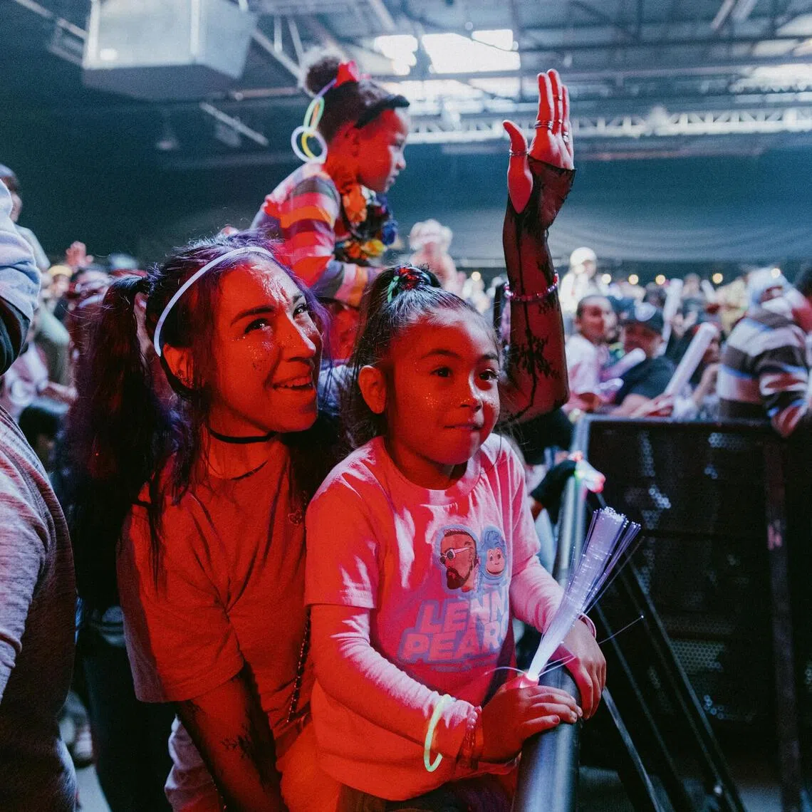 Maria Sabangan listens with her daughter Avianna, 5, as Lenny Pearce takes the stage for the ‘baby rave’ in San Francisco, Nov. 22, 2025. Everyone loves tiny dancers. Now some artists are considering why they bring us such joy — and what lessons they might have for grown-ups. (Jason Henry/The New York Times)