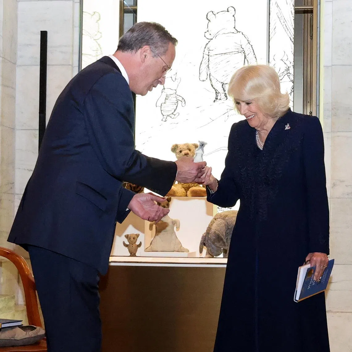 Queen Camilla presents a specially-made replica of Roo to Mr Anthony Marx, CEO of the New York Public Library.