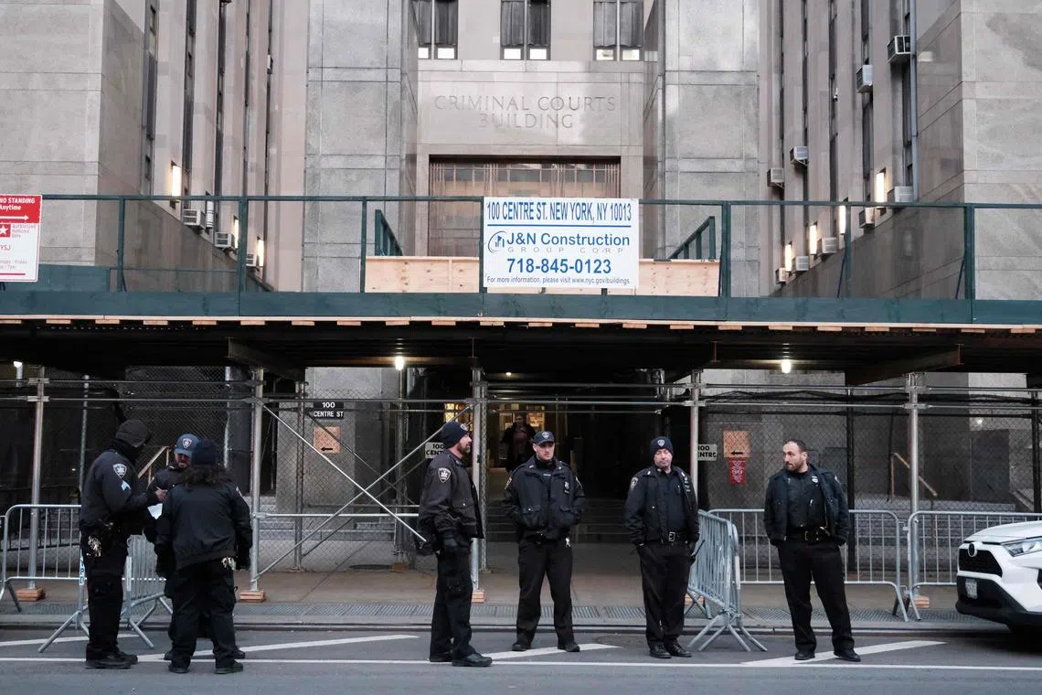 Police, media and a small group of protesters gather outside of a Manhattan courthouse on Thursday after news broke that former President Donald Trump had been indicted by a grand jury. 