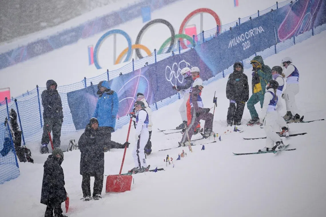Milano Cortina 2026 Olympics - Freestyle Skiing - Women's Aerials Qualifications - Livigno Aerials & Moguls Park, Livigno, Italy - February 17, 2026.  Athletes wait as the Women's Aerials Qualifications are delayed due to heavy snow REUTERS/Dylan Martinez