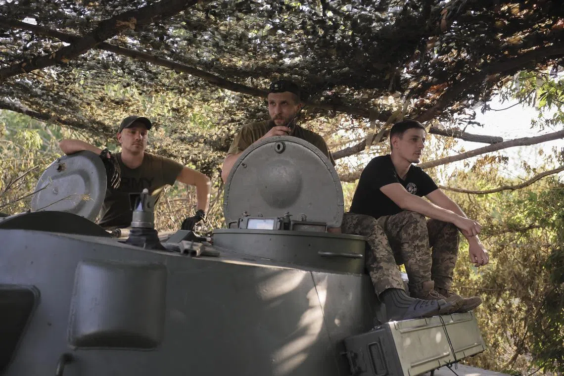 Ukrainian servicemen resting on a self-propelled howitzer, near the front-line city of Chasiv Yar, in Ukraine's Donetsk region, on June 30.