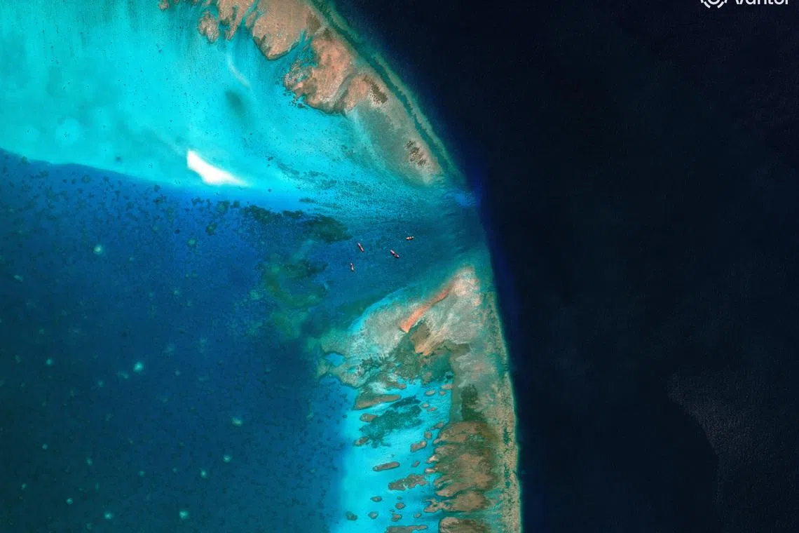 A satellite image of fishing vessels at the entrance, which is blocked by a floating barrier, to the disputed Scarborough Shoal, in the South China Sea, April 11, 2026. Vantor/Handout via REUTERS