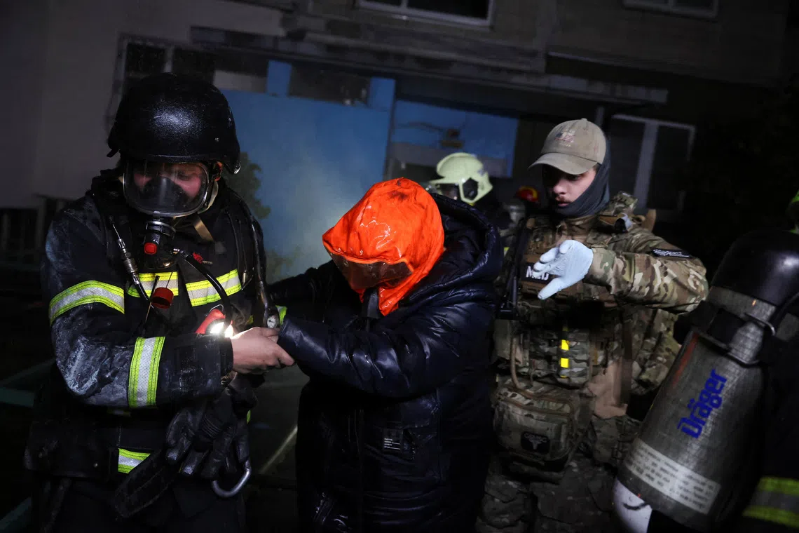 A person is assisted at the site of an apartment building damaged by a Russian missile strike in Kyiv, Ukraine, on Oct 13.
