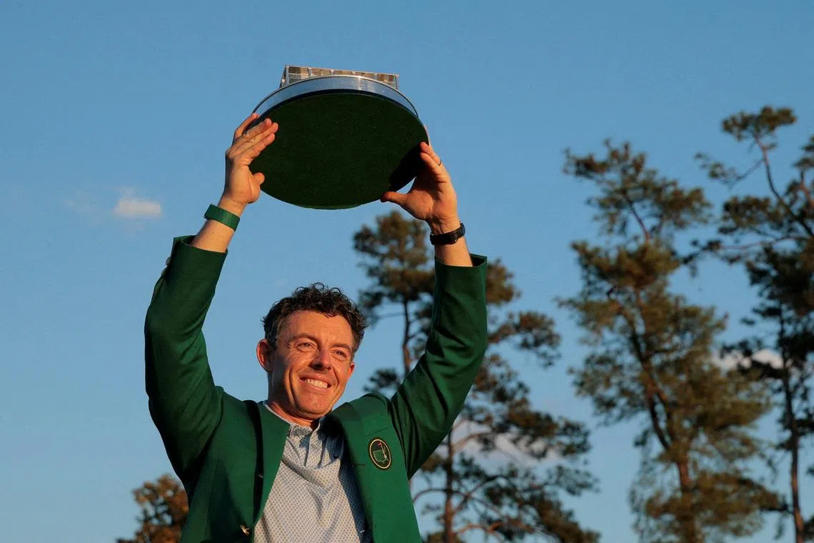 Golf - The Masters - Augusta National Golf Club, Augusta, Georgia, U.S. - April 12, 2026 Northern Ireland's Rory McIlroy celebrates with his green jacket and the trophy after winning The Masters REUTERS/Brian Snyder