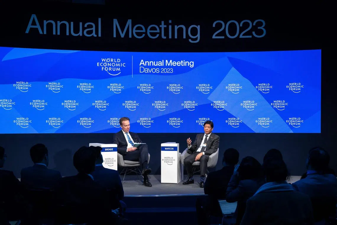 Philippine's President Ferdinand Marcos Jr (R) speaks next to WEF president Borge Brende during a session at the World Economic Forum