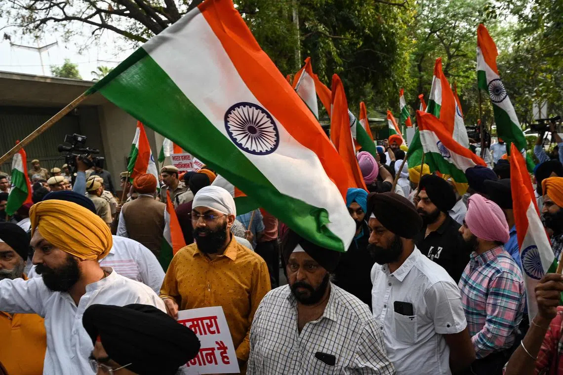 Sikh men hold Indian national flags during a protest in New Delhi on March 20, 2023, against the supporters of radical Sikh preacher Amritpal Singh, who were filmed vandalising India's consulate in San Francisco, not long after similar disturbances in London. 
