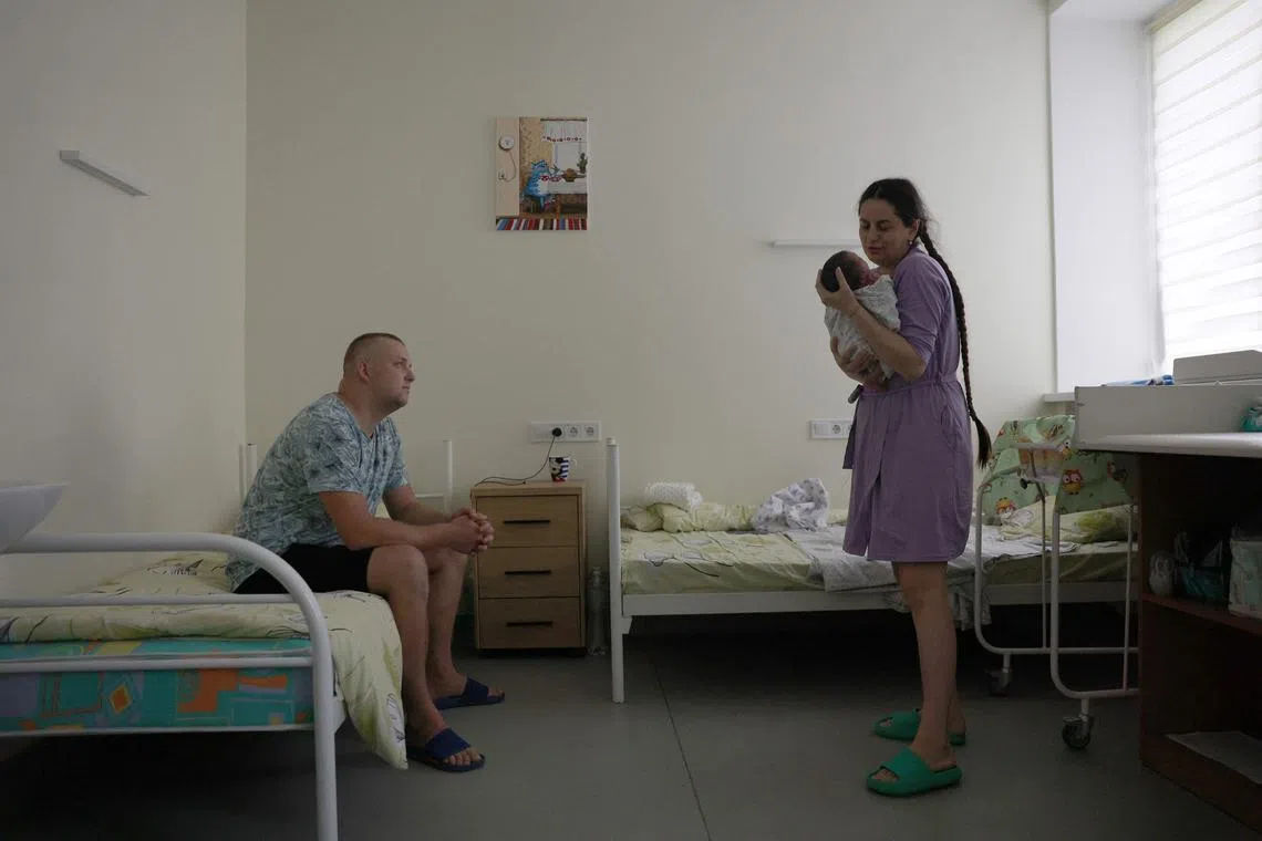 Rescuer Vitaly, his wife Kateryna and their daughter Dasha, who was born 9 days before, are seen in the ward of the Perinatal centre of Pokrovsk, Donetsk region on July 20, 2024.