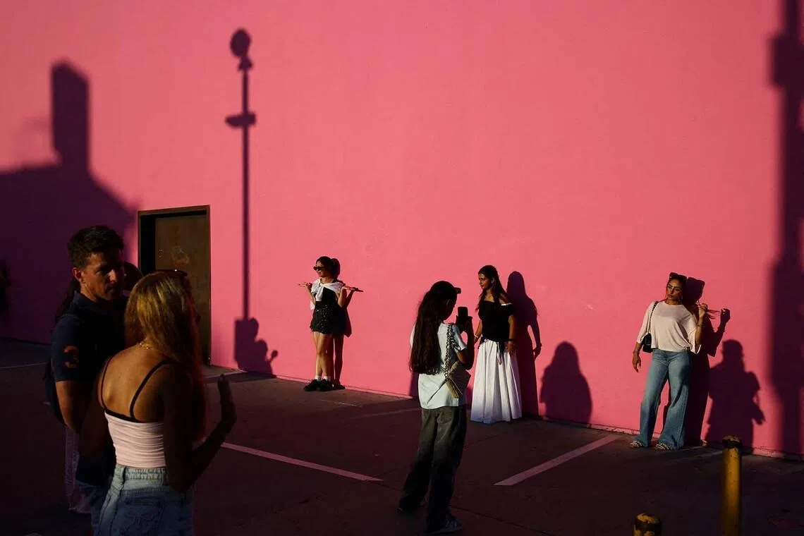 People pose for pictures along the Pink Wall on Melrose Avenue in Los Angeles, California, U.S., July 28, 2026. REUTERS/Daniel Cole TPX IMAGES OF THE DAY